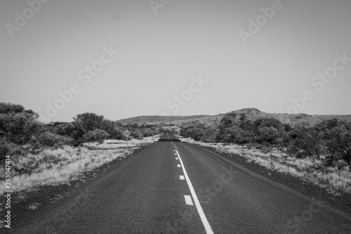 Dust and bushes next to road at Karijini National Park Australia in black and white
