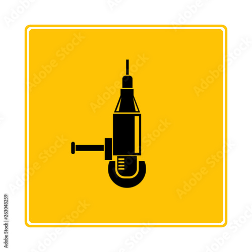 electric drill machine on yellow signage