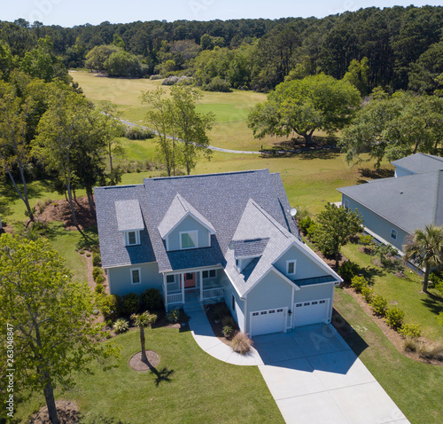 Low aerial view of house with new roof and golf course behind. photo