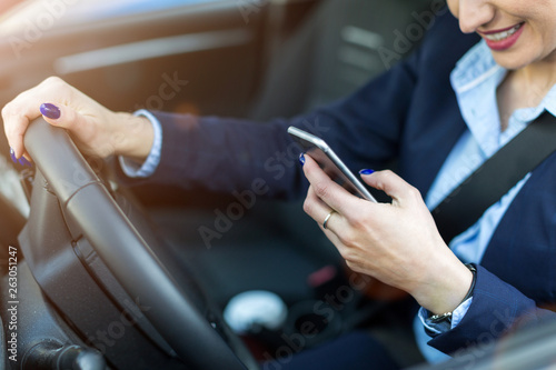 Woman using smartphone while driving a car