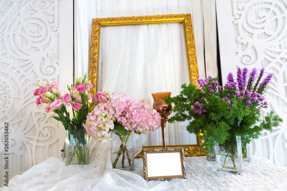 Picture frame and flowers on a dresser in a wedding room.