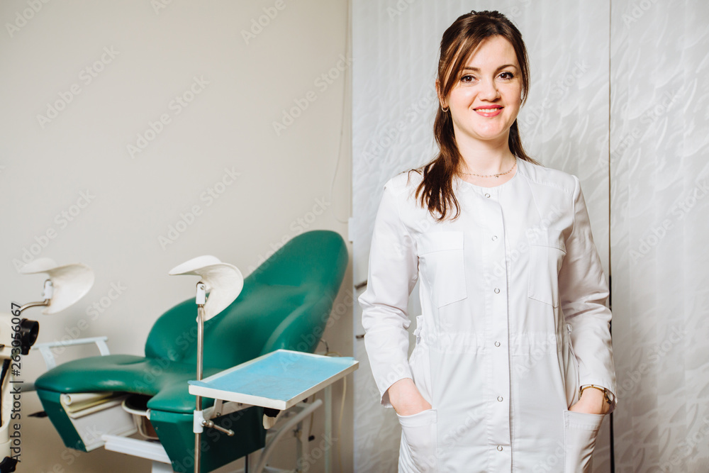 Professional positive friendly female doctor on modern consulting room background. Gynecology, women's health - real people model concept. Professional positive friendly female doctor on modern consulting room background. Gynecology, women's health - real people model concept.