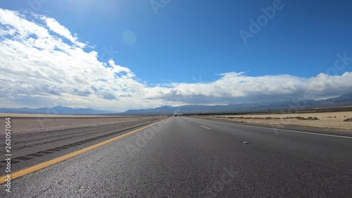 Driving view of Interstate 15 freeway crossing desert dry lake near Primm Nevada in Southern California.   photo