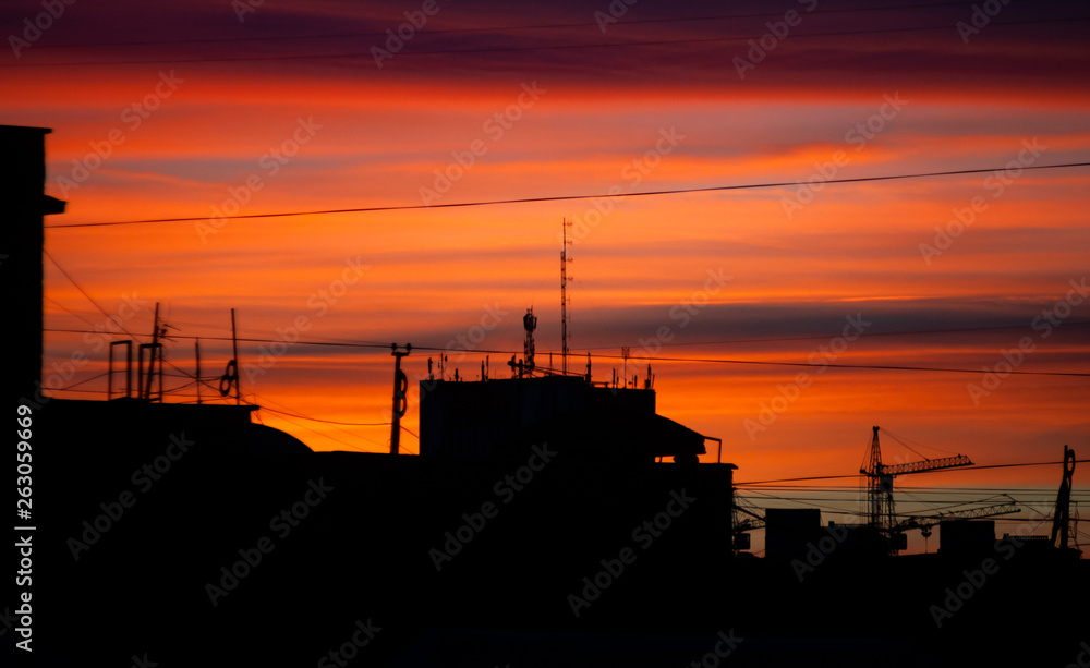 Urban panorama with dramatic dark red sunrise