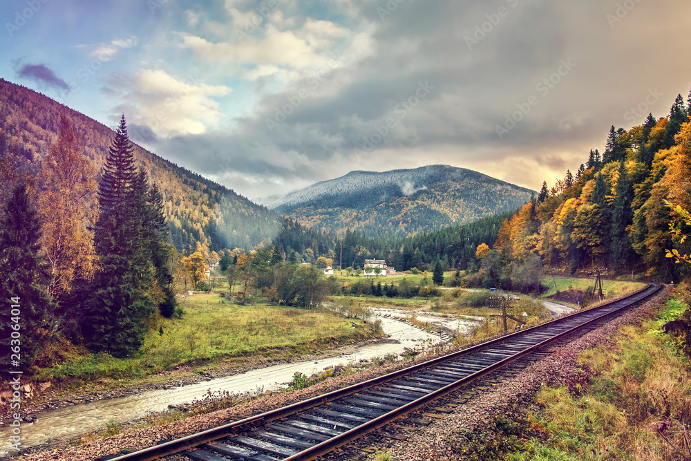 Dramatic Picturesque Scene. railway in the autumn Mountain landscape. Overcast Clouds over the mountains. Concept of Travel. Retro Style . Dramatic Picturesque Scene. railway in the autumn Mountain landscape. Overcast Clouds over the mountains. Concept of Travel. Retro Style .