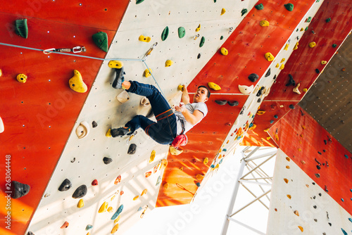 Sport man hanging extreme sport climbing wall in outdoor gym