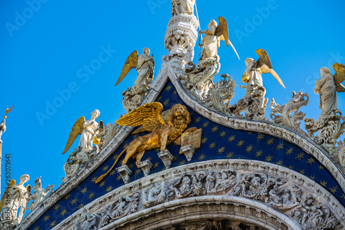 Detail of a facade of Basilica di San Marco, golden lion with wings holding a book, Venice, Italy 