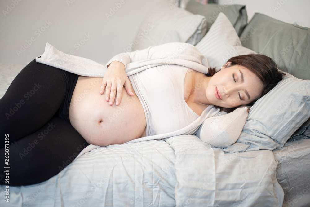 Beautiful asian pregnant woman is sleeping on bed Beautiful asian pregnant woman is sleeping on bed