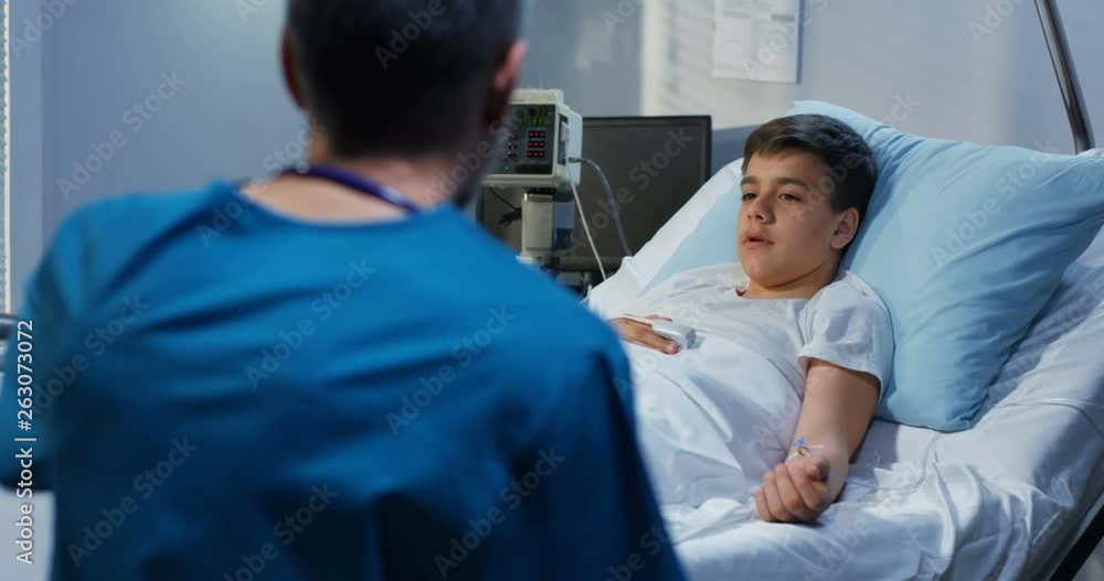 Teenager patient talking his doctor in hospital Teenager patient talking his doctor in hospital