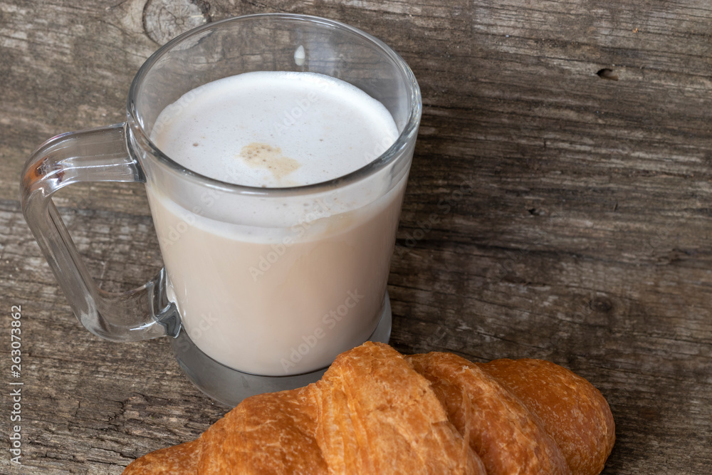 French breakfast with croissant and cappuccino over wooden background French breakfast with croissant and cappuccino over wooden background