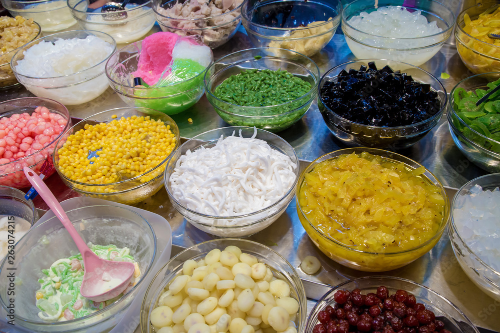 Mix dessert with ice, sweet and herb on sale. Varieties of colorful Thai dessert. Topping mixed for Thai ice dessert. Thai sweet dessert Khanom Thai and fruit bar with variety of raw. Mix dessert with ice, sweet and herb on sale. Varieties of colorful Thai dessert. Topping mixed for Thai ice dessert. Thai sweet dessert Khanom Thai and fruit bar with variety of raw.