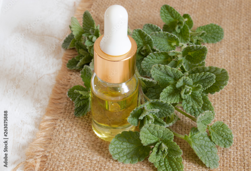 Essential aromatic oil with mint on wooden background. Selective focus. Essential aromatic oil with mint on wooden background. Selective focus.
