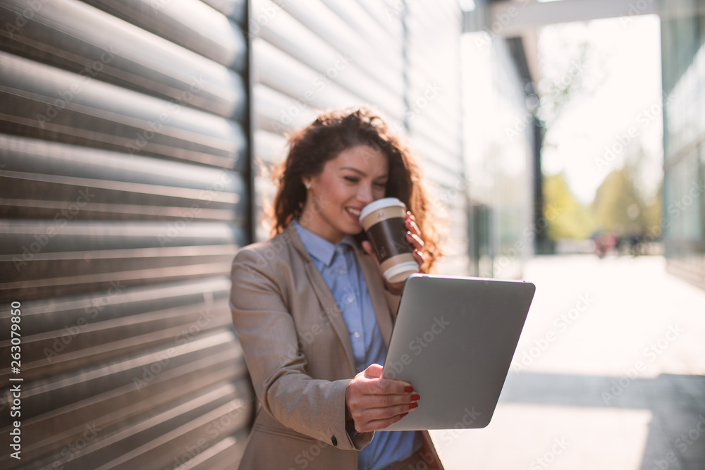Businesswoman drinking coffee and using tablet Businesswoman drinking coffee and using tablet