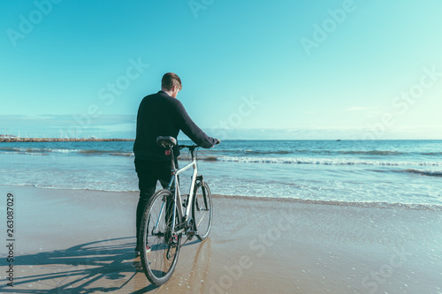 Man riding bicycle on beach