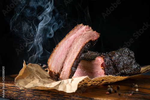 Sliced smoked beef brisket with dark crust from classic Texas BBQ smokehouse photo