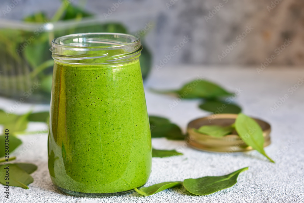 Fresh, green smoothie with spinach on a concrete background. Fresh, green smoothie with spinach on a concrete background.
