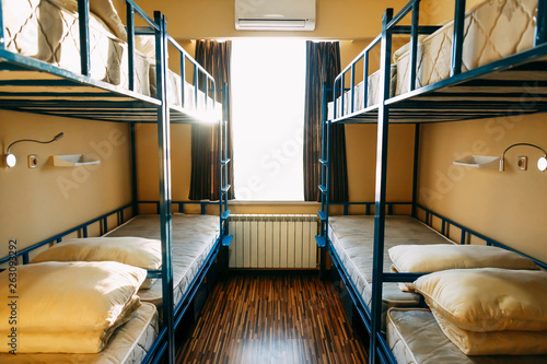 Fotografie Backpackers stay in hotel with modern double-decker beds inside the dorm room fo