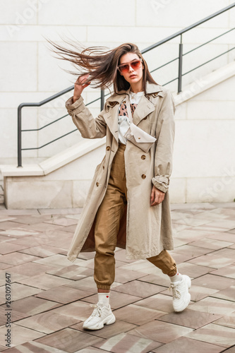 Portrait shooting of a stylish girl. Beige shades. Trends of spring and summer 2019. Pants of cork.Trench cloak, a wide jacket.