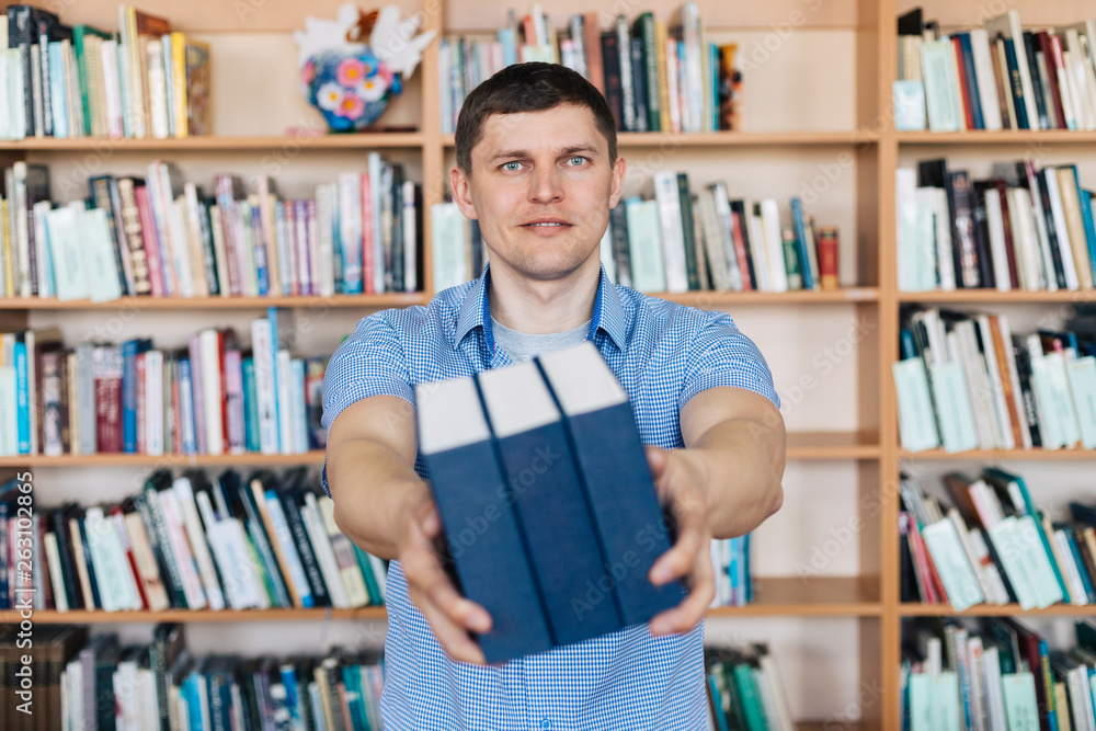 Male hands holding a stack of books. Man holds out a stack of books Male hands holding a stack of books. Man holds out a stack of books
