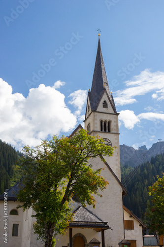 View of Church surrauded by mountains in Arabba village, Dolomites Alps, Italy
