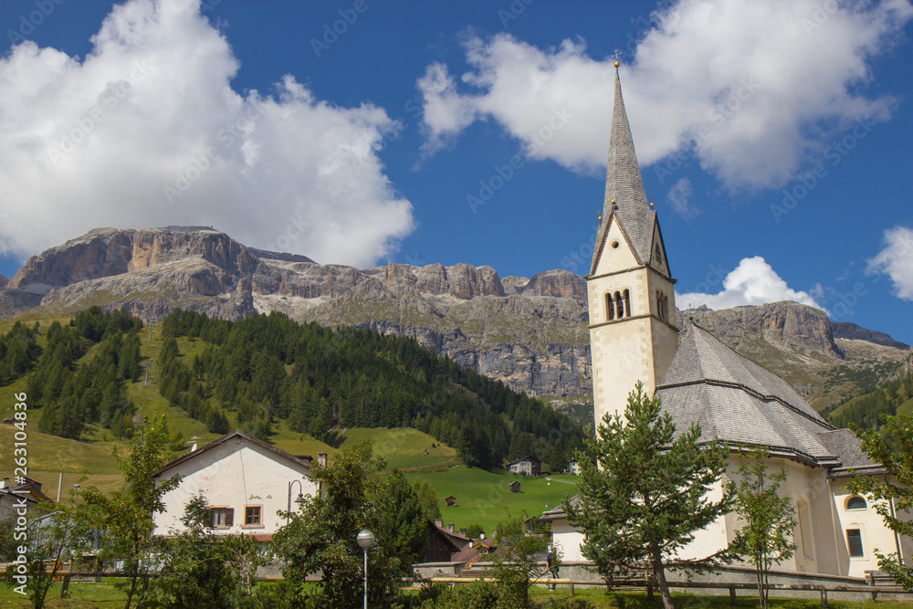 View of Church surrauded by mountains  in Arabba village, Dolomites Alps, Italy