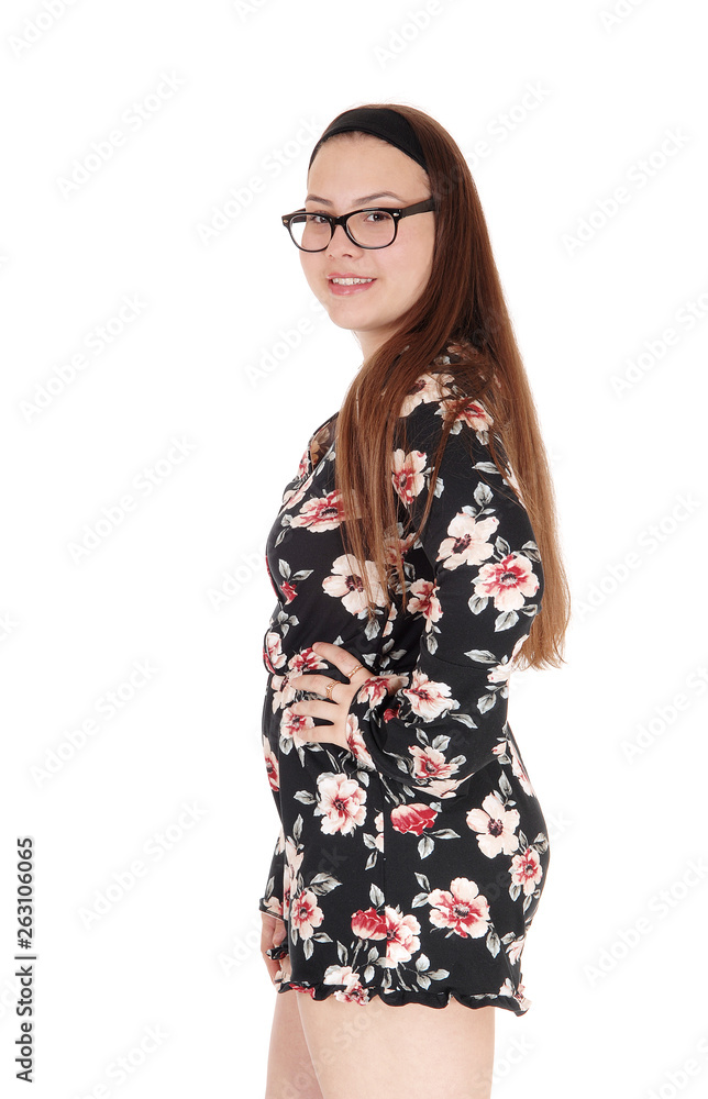 Beautiful teenage girl standing in shorts in profile Beautiful teenage girl standing in shorts in profile