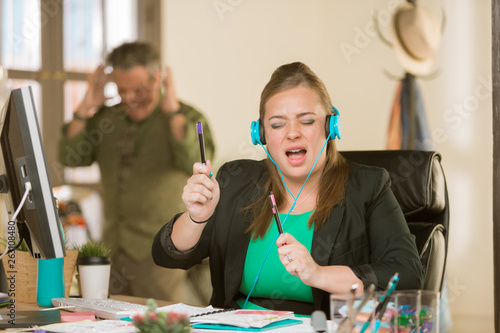 Foto Woman with Headphones Singing Loudly and Annoying Colleague