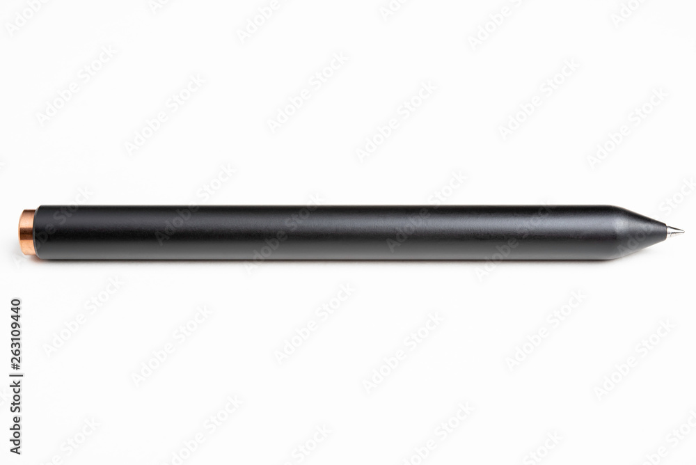 An extreme close-up or macro shot of a minimalist black barrel ballpoint pen with selective focus on tip set against plain white background. An extreme close-up or macro shot of a minimalist black barrel ballpoint pen with selective focus on tip set against plain white background.