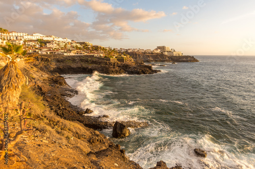 waves splashing on the rocky shore in sunset light in tenerife los gigantes area