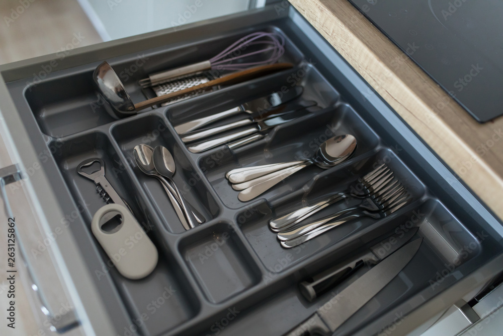 Service set of cutlery set: silver spoons, forks and knifes. Kitchen supplies close up view. Ready to eat concept. Service set of cutlery set: silver spoons, forks and knifes. Kitchen supplies close up view. Ready to eat concept.