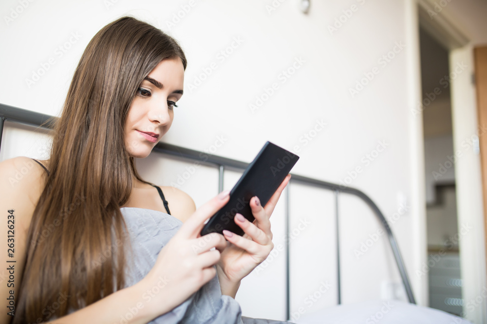 technology, internet, christmas and people concept. Young woman lying in bed with tablet pc computer at home bedroom technology, internet, christmas and people concept. Young woman lying in bed with tablet pc computer at home bedroom