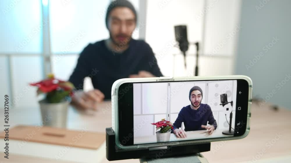 Young male vlogger recording a video of himself talking to the camera to be then published on the internet. Young male vlogger recording a video of himself talking to the camera to be then published on the internet.