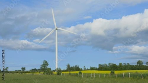 Modern wind turbine. Beautiful sky with clouds and crops in farmer�s field. Wind sound but no shake. Shot with solid heavy tripod. Grey County, Ontario, Canada photo