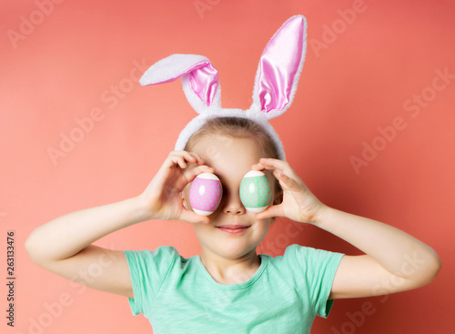 Studio shot of a happy young girl wearing bunny ears front of her eyes