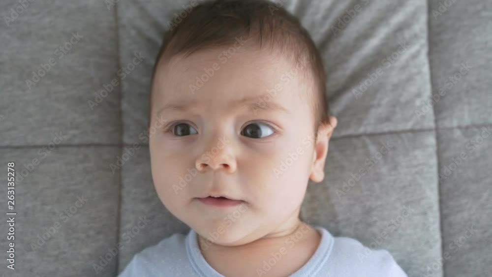 Cute baby face with brown eyes. The look of the baby in the camera close-up shot Cute baby face with brown eyes. The look of the baby in the camera close-up shot