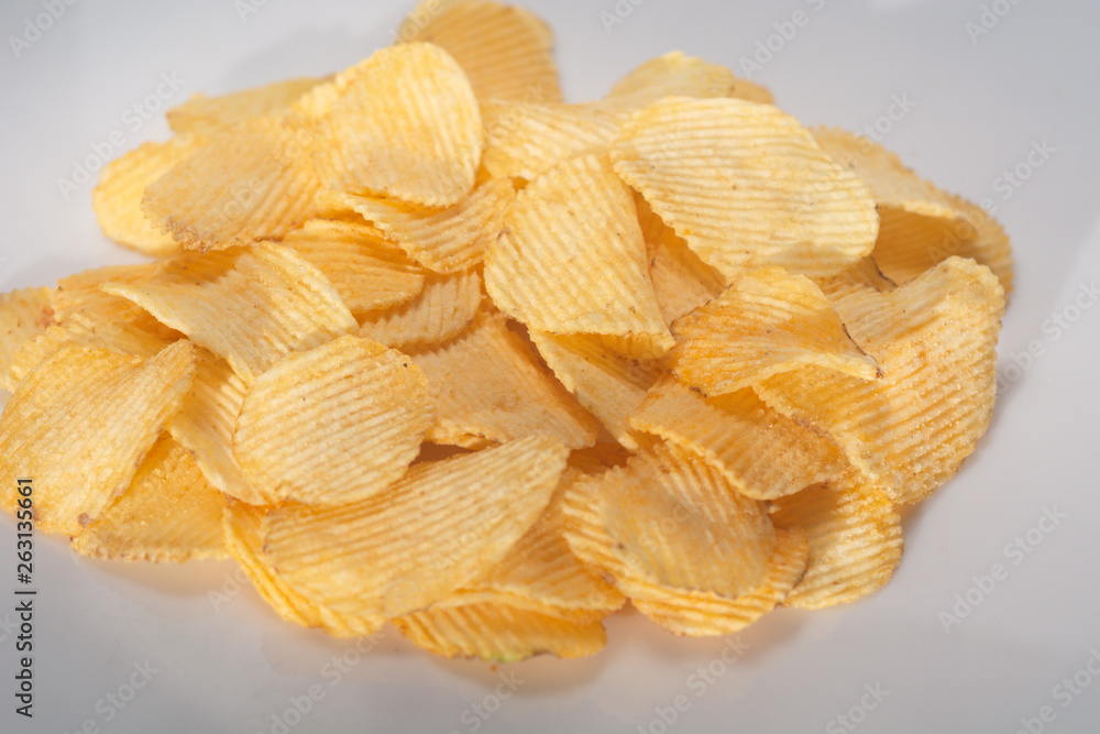 Close-up lot of tasty rippled yellow potato chips background Close-up lot of tasty rippled yellow potato chips background