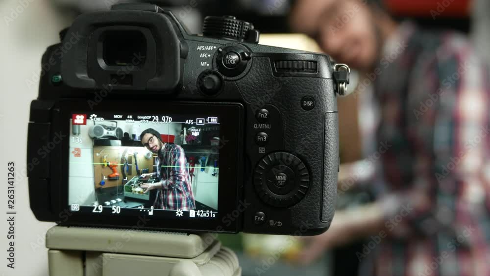 Millennial youtuber recording a video of himself in a workshop talking to his audience watching on the internet. Millennial youtuber recording a video of himself in a workshop talking to his audience watching on the internet.