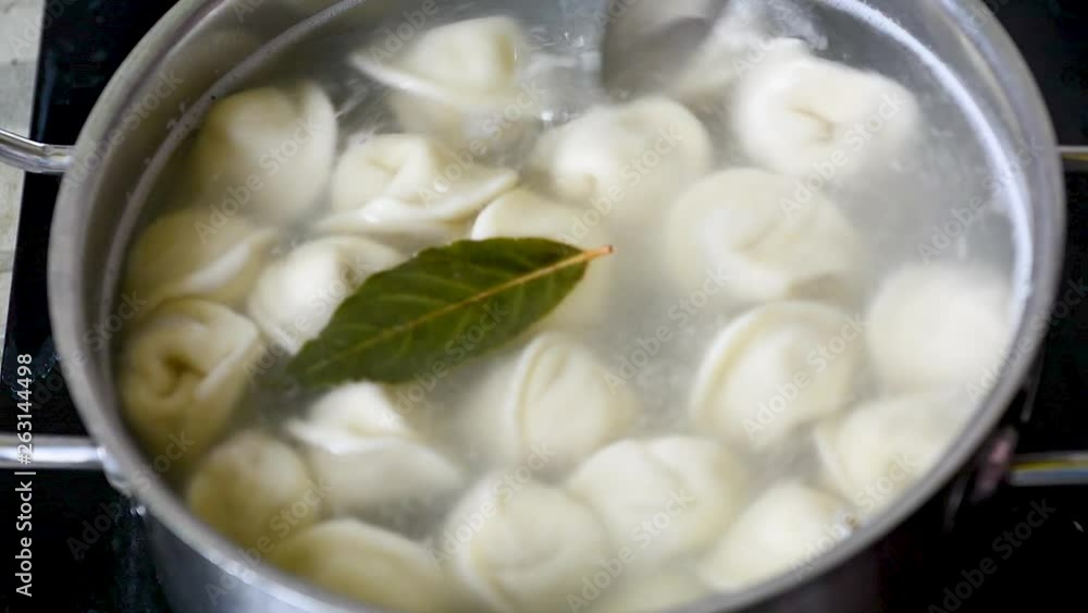 Ravioli boiling in water with spices Close-up of dumplings on a skimmer over a pan of boiling water. Home cooking Ravioli boiling in water with spices Close-up of dumplings on a skimmer over a pan of boiling water. Home cooking