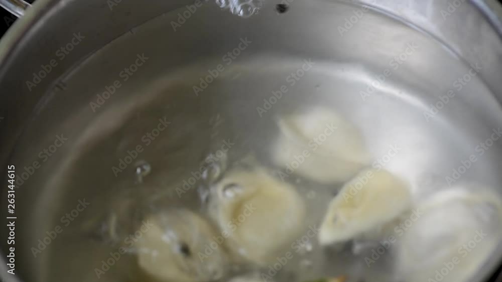 Ravioli boiling in water with spices Close-up of dumplings on a skimmer over a pan of boiling water. Home cooking Ravioli boiling in water with spices Close-up of dumplings on a skimmer over a pan of boiling water. Home cooking