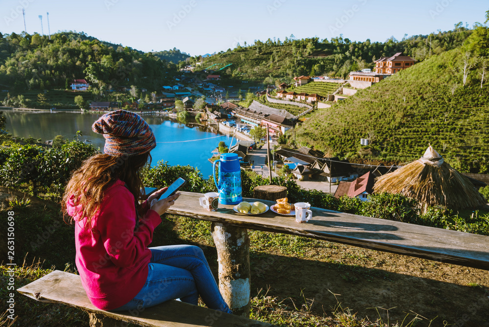 The Girl travel on the mountain. She is watching the scenery beautiful of Ban Rak Thai village, Drink coffee and eat food, snack in the morning.
