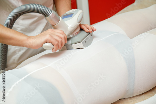 Woman having anti cellulite lpg massage with spa apparatus photo