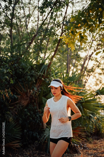 Woman runner looks at her watch checking her running time from smart watch. Athletic girl ready to run and looking at sport smart watch. Healthy runner checking performance. © EduLife Photos