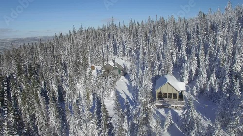 Aerial view of Two cottages in the Canadian winter surrounded by white trees atop the Monts Valin in the Saguenay region of Quebec photo