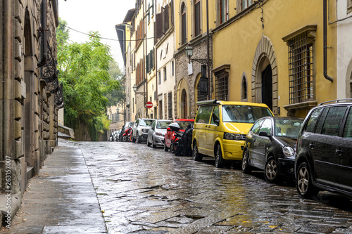 Rainy Alleyway - An Autumn rainy day at a quiet alley in the historical Old Town of Florence. Tuscany, Italy. No trademark, logo or person in the image. The main subject is the paved one-way street.