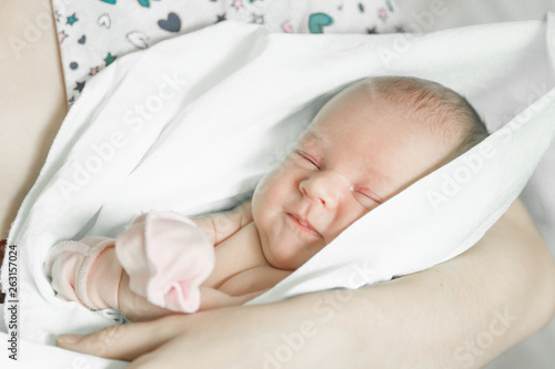 Sleeping newborn baby closeup portrait in mother's hands