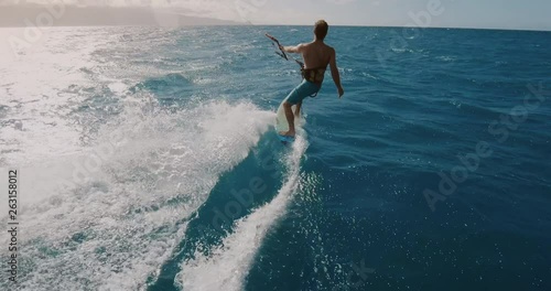 Young athletic man kitesurfing POV follow cam in slow motion, extreme action sports POV, tropical island surf adventure