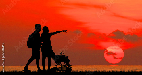 silhouette happy family on the beach at sunrise time