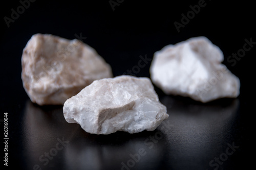 The white stones of the mineral gypsum on a black background.