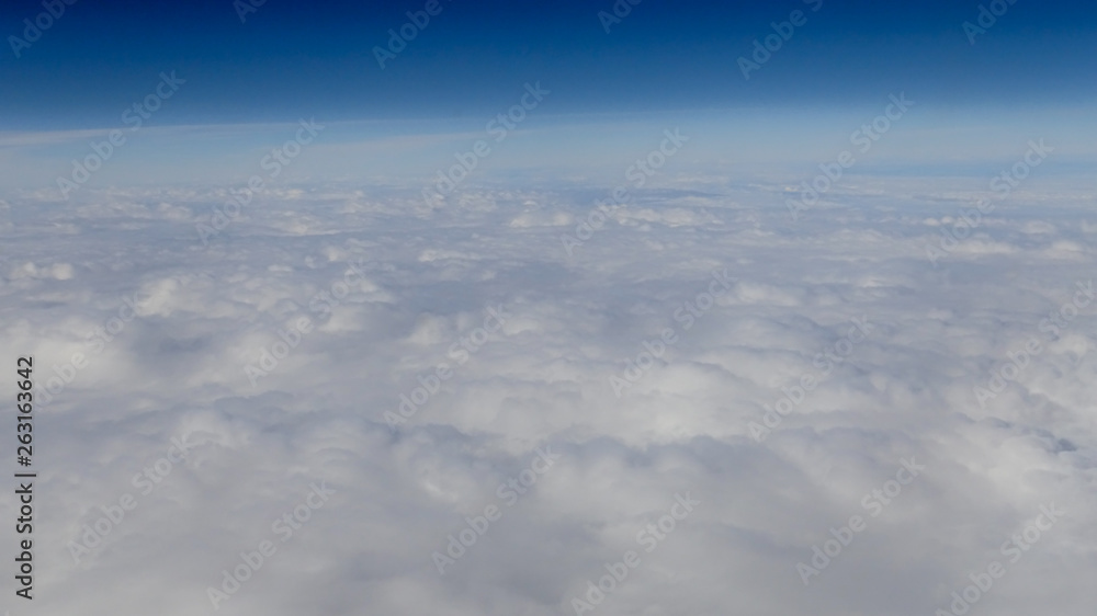Fototapeta premium The beautiful cloudscape with clear blue sky. A view from airplane window.