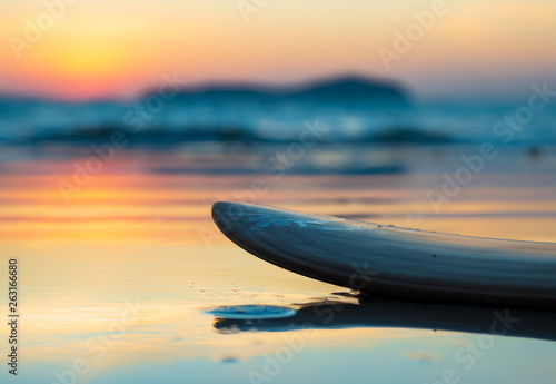 surfboard on the beach in sea shore at sunset time